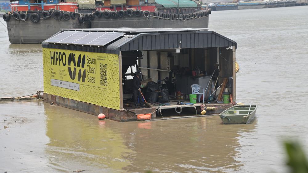 Une imposante barge flottante se dresse sur le fleuve Chao Praya, récoltant le plastique à la dérive. © Camille Carvalho